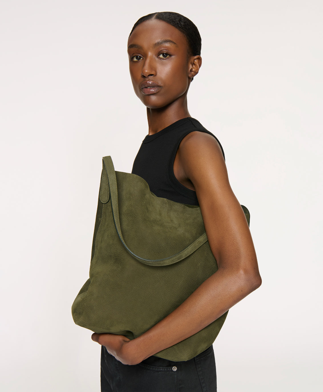 Side view of Everyday Cabas in algae showcasing slouchy nubuck leather and elongated handles against a plain light background