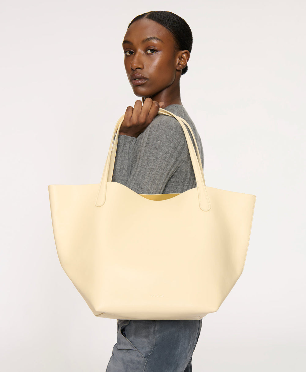 Side view of Everyday Soft Tote in Crema showing soft structured silhouette and reinforced handles against light background
