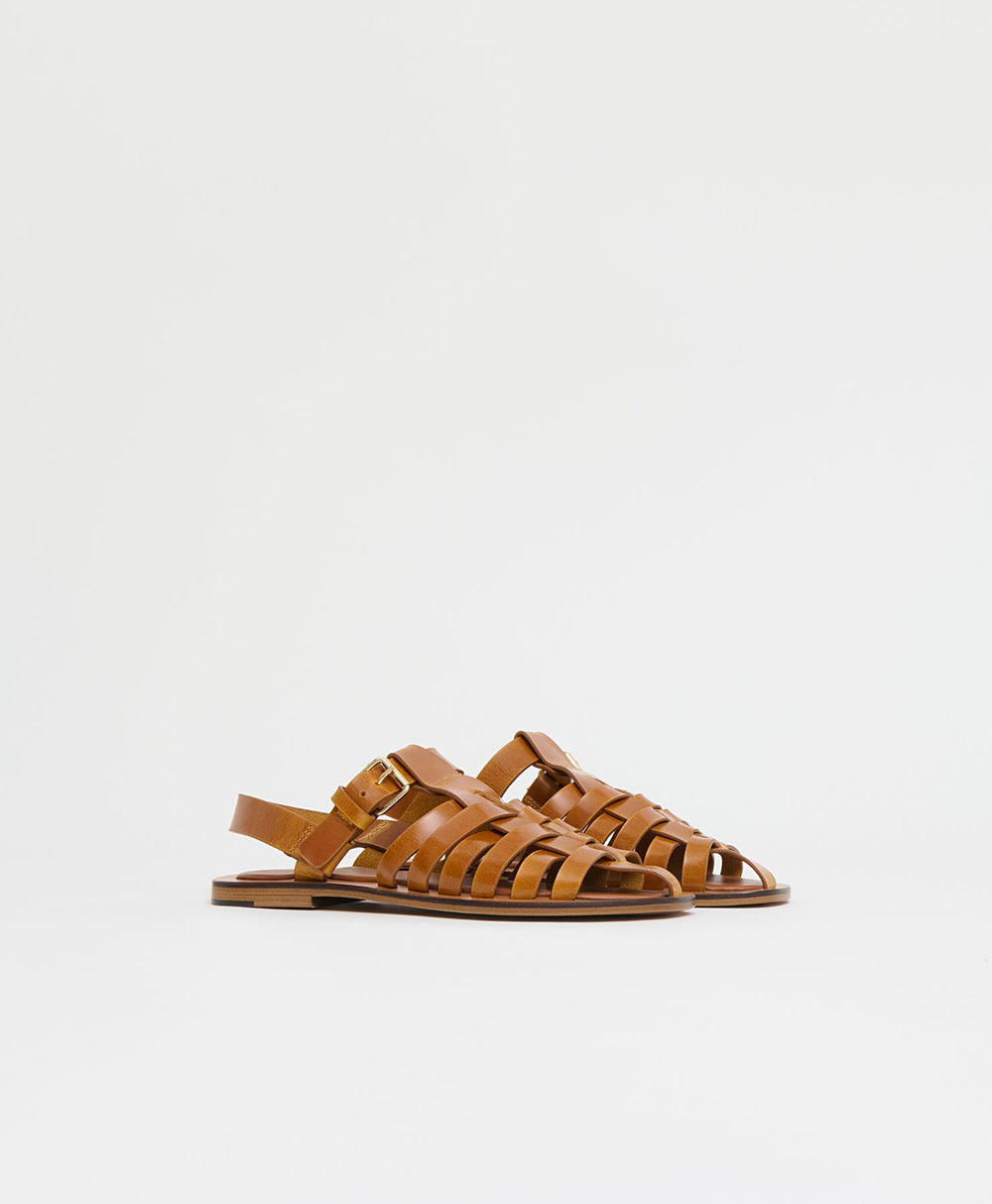Side view of Netta Sandal in Ocra showcasing woven upper, buckled slingback strap and flat sole on white background