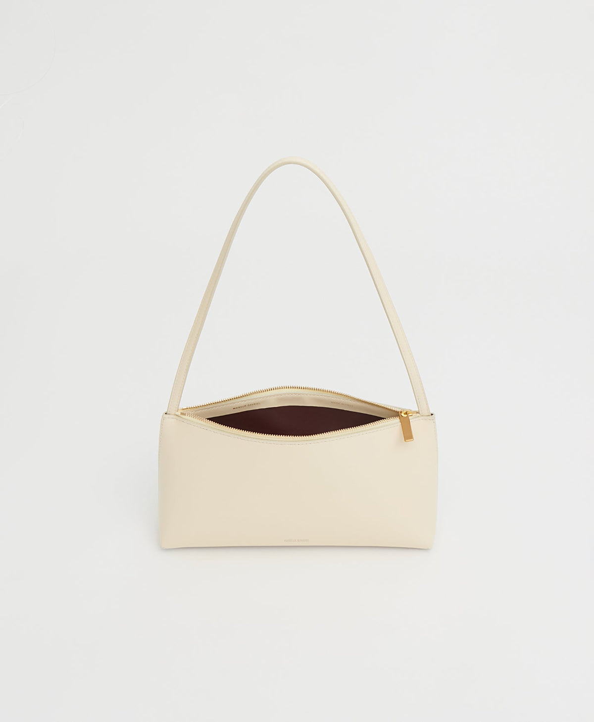 Front view of Gaia Shoulder Bag in crema showcasing open top zipper, slim shoulder strap, and contrasting dark interior against white background