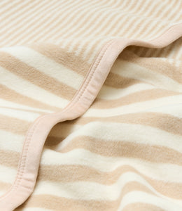 Beige and cream striped blanket with pink binding edge, folded to show texture and stitching detail.