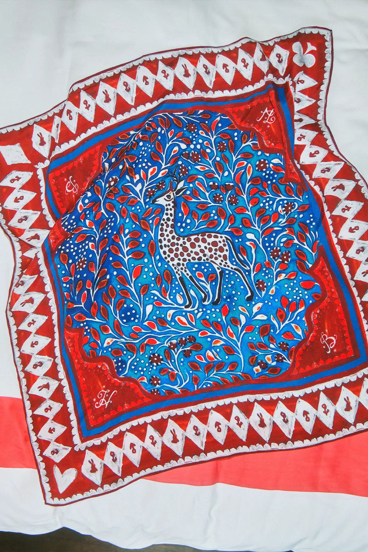 Double-sided printed scarf showcasing a whimsical winter tableau with a charming fawn at the center.