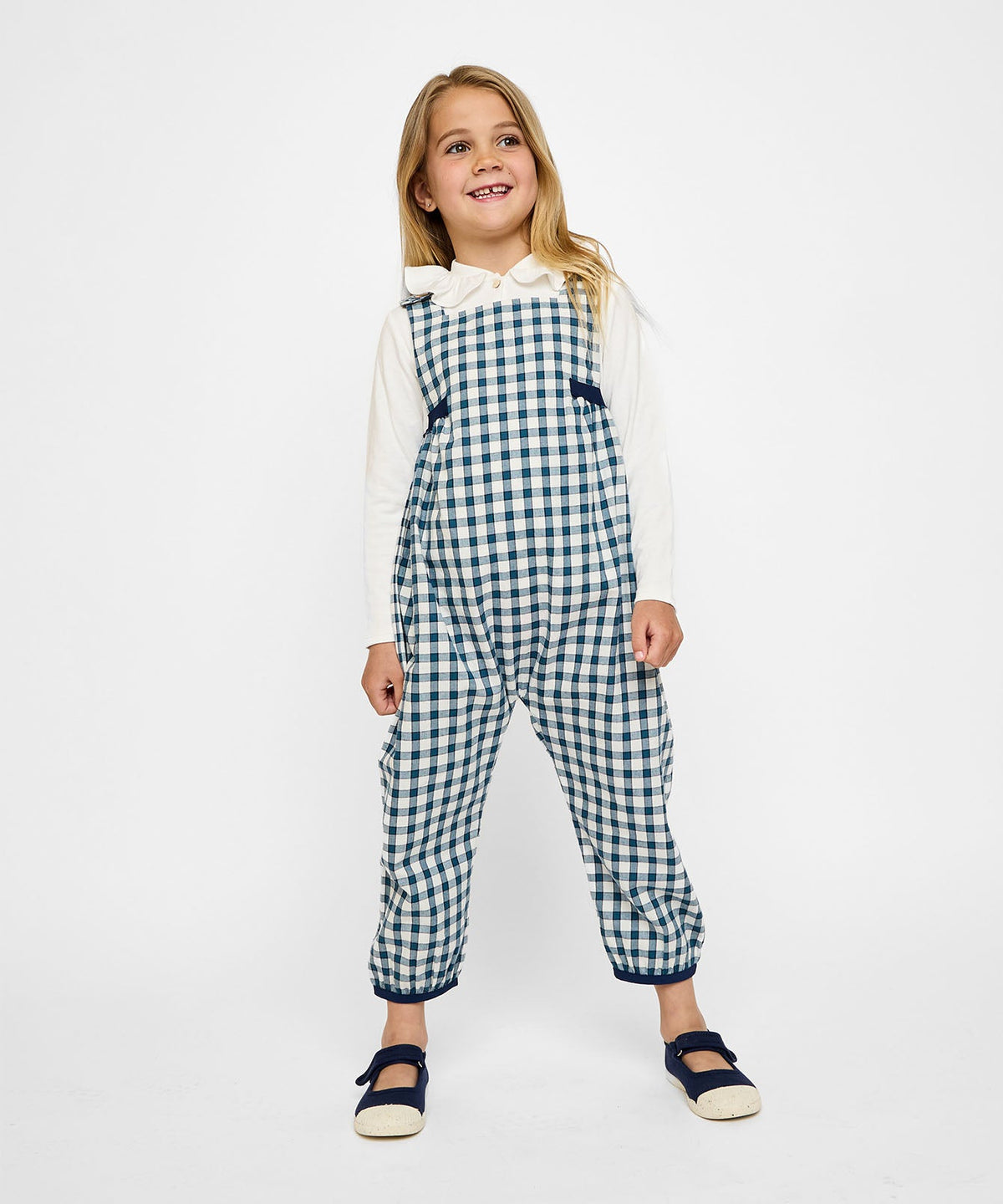 Front view of Scout Overall in blue picnic check on a child model showing relaxed fit, ankle-length legs, and navy trim on a white background