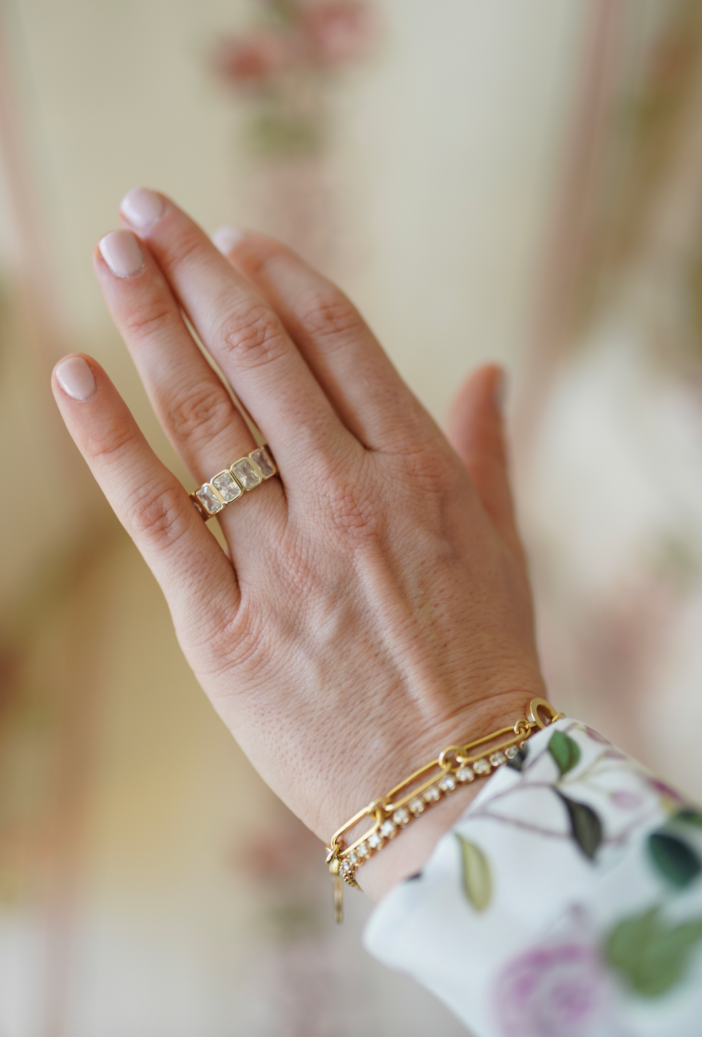 Close-up of the Grand Blanc Baguette Band showcasing gold-plated rectangular glass stones on a hand