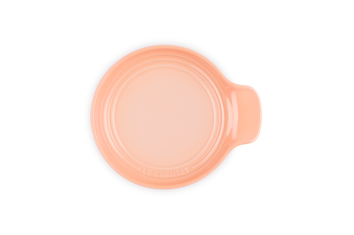 Top view of Signature Spoon Rest in Peche showcasing raised ridges and handle on white background