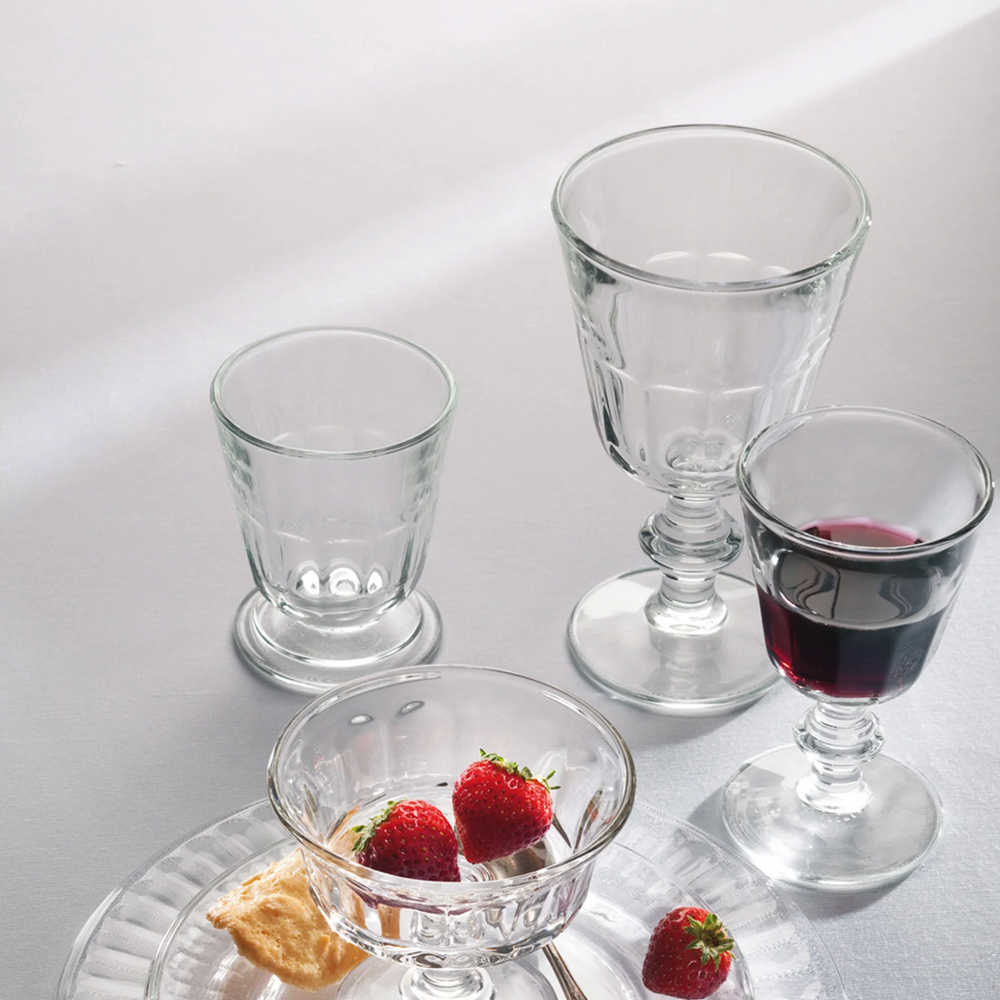 Angled view of Perigord tumbler set showcasing clear ridged glass texture and footed base on a light tabletop