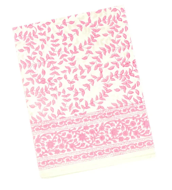 Angled view of Pink Leaves Tablecloth showcasing pink leafy block print and floral border on a white background