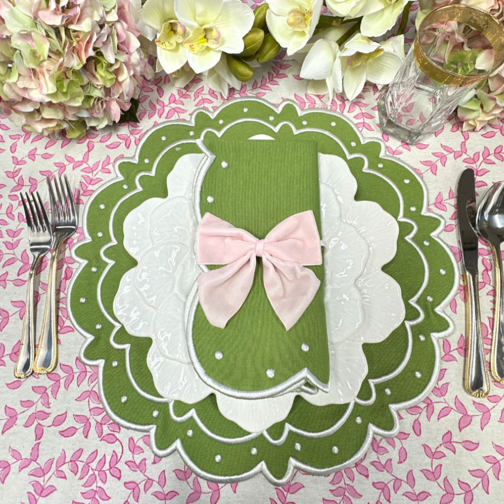 Overhead view of Pink Leaves Tablecloth showing pink leaf block print with green scalloped placemat and pink-bow napkin