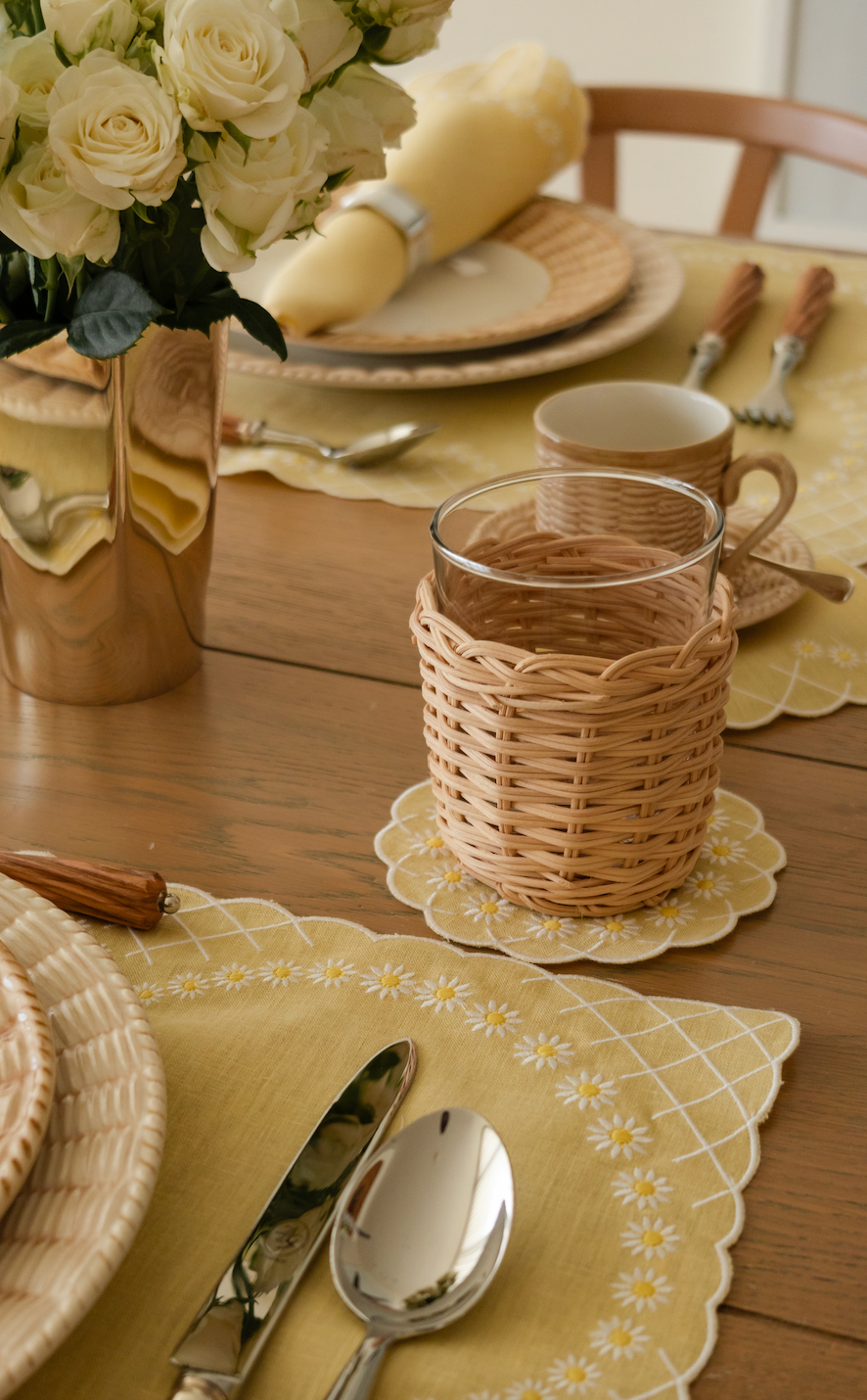 Close-up of Daisy coaster in yellow showcasing embroidered scalloped edge and daisy motif on a styled wooden table
