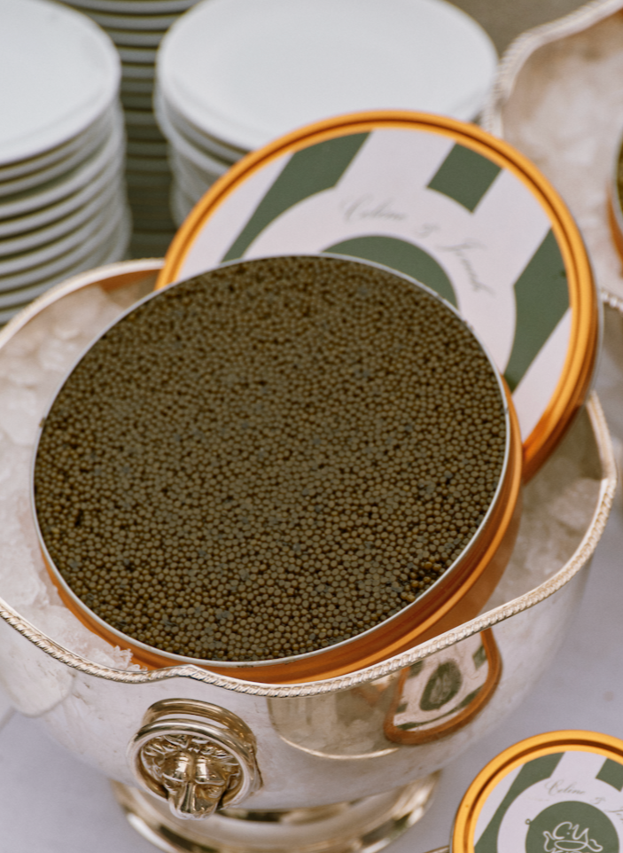 Top view of bespoke wedding kilo tin of golden Ossetra caviar showcasing densely packed pearls in a copper-rimmed personalized tin inside a silver ice bucket
