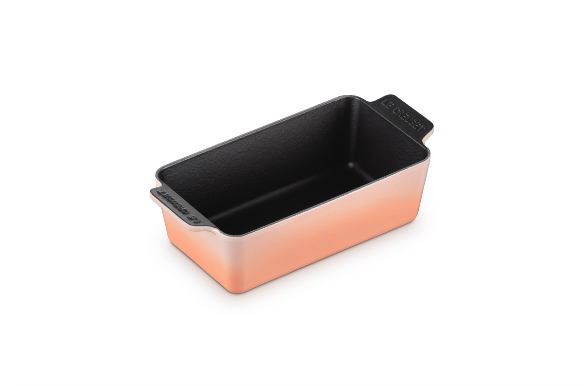 Angled view of Heritage Loaf Pan in Peche showcasing scalloped handles and dark interior with white background