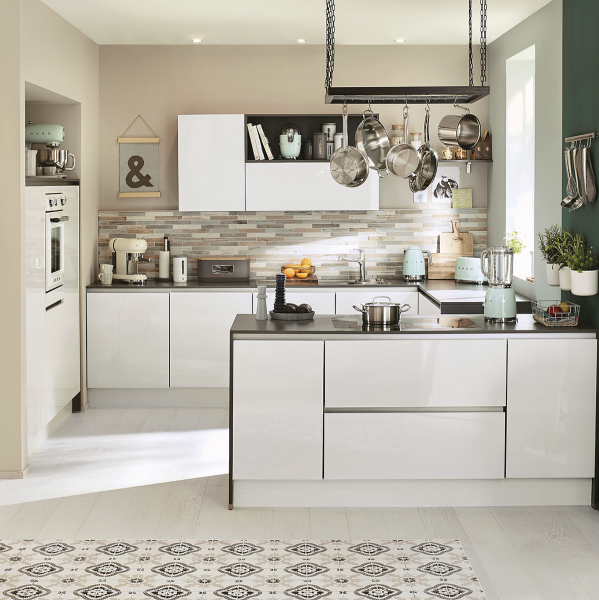 Pastel green Smeg variable temperature kettle on a countertop in a bright styled kitchen with matching appliances