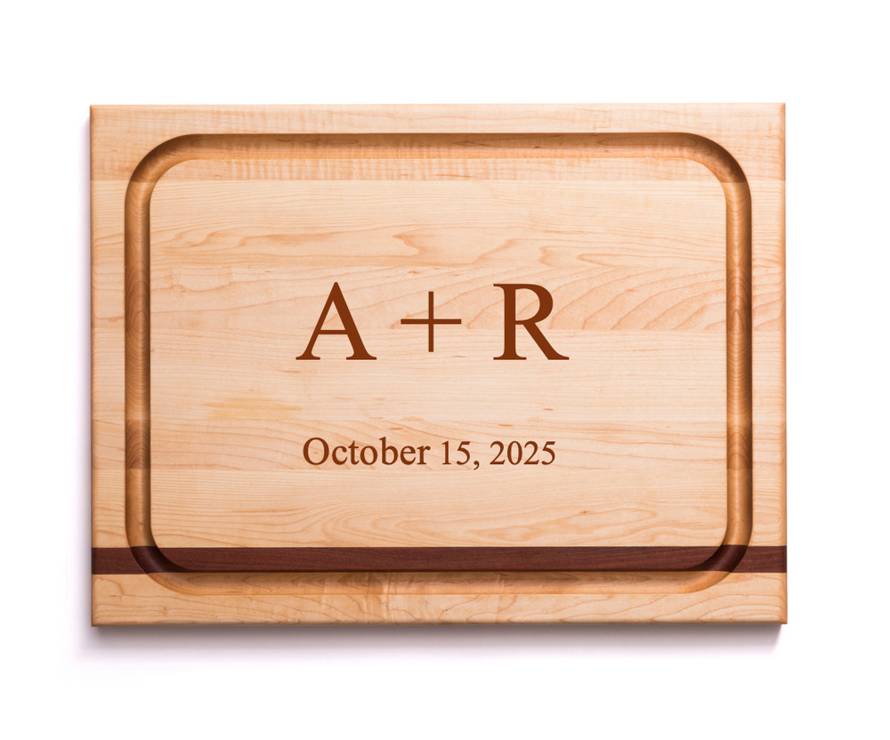 Top view of maple carving board with mahogany inlay and juice groove, engraved ‘A + R’ and ‘October 15, 2025’