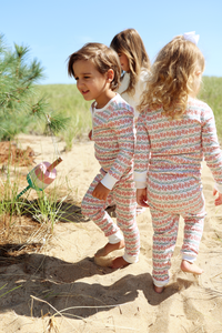 Side and rear view of Christmas Lobsters Kids Henley Pajamas on two children, showing lobster print on a sandy beach