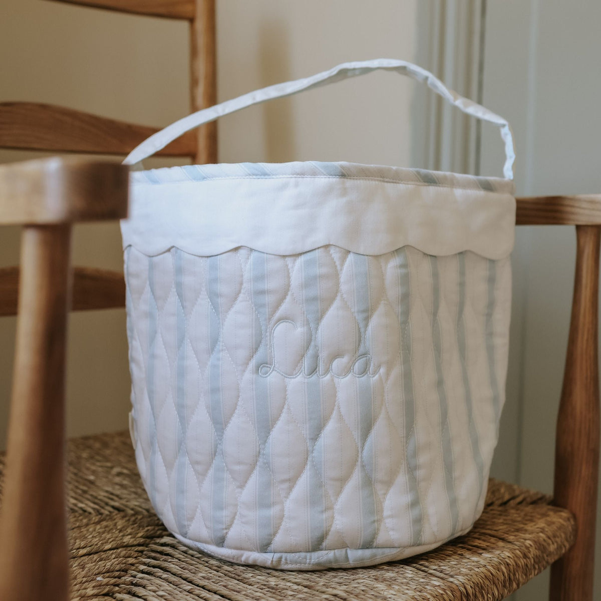 Quilted fabric basket with scalloped edge on a wooden chair
