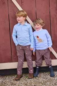 Little English traditional children's clothing.  Classic long sleeve light blue polo and chocolate brown corduroy pants with seated lab embroidery for boys.  Light blue crew neck intarsia sweater with seated lab motif layered over lab printed turtleneck and paired with chocolate brown corduroy banded pants.