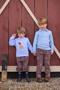 Little English traditional children's clothing.  Classic long sleeve light blue polo and chocolate brown corduroy pants with seated lab embroidery for boys.  Light blue crew neck intarsia sweater with seated lab motif layered over lab printed turtleneck and paired with chocolate brown corduroy banded pants.