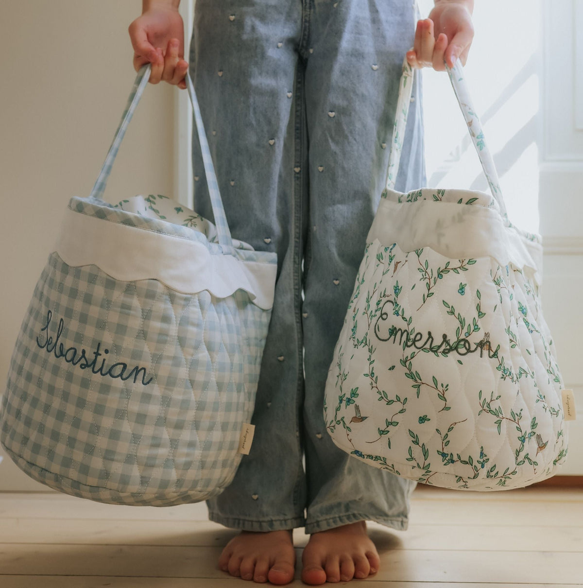 Child holding two quilted children's baskets.