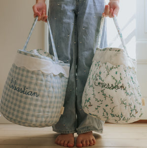 Child holding two quilted children's baskets.