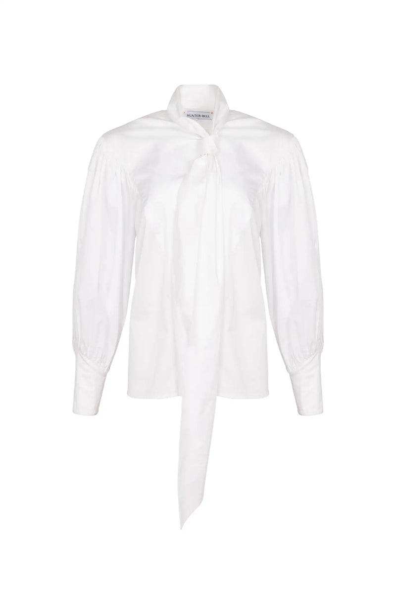 The Shay Blouse is designed with a tie-front neckline and long sleeves with angled button cuffs
