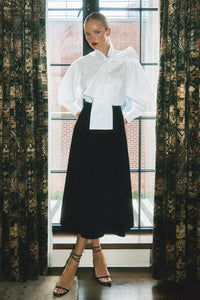 The Shay Blouse is designed with a tie-front neckline and long sleeves with angled button cuffs