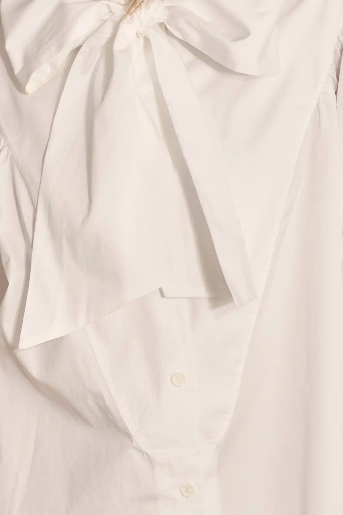 The Shay Blouse is designed with a tie-front neckline and long sleeves with angled button cuffs