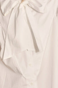 The Shay Blouse is designed with a tie-front neckline and long sleeves with angled button cuffs
