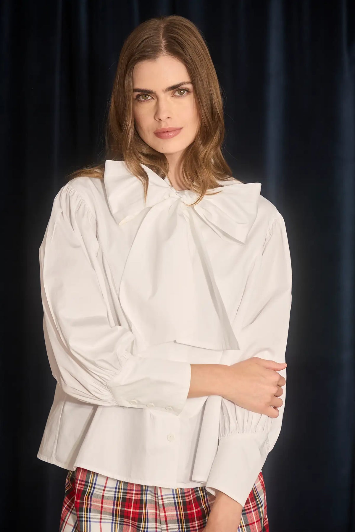 The Shay Blouse is designed with a tie-front neckline and long sleeves with angled button cuffs
