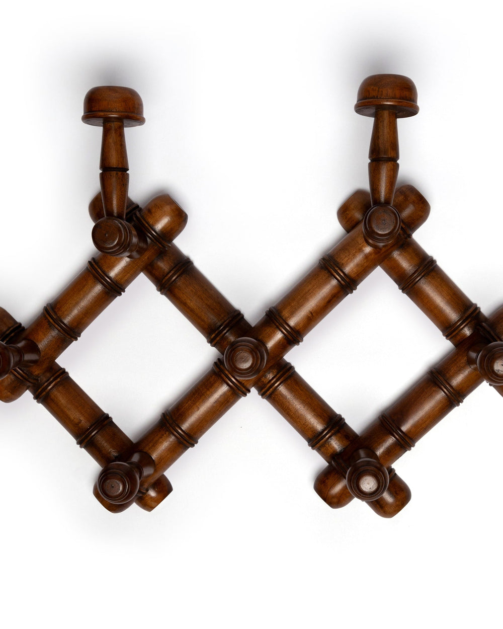 Close-up top view of mahogany 7-hook wooden coat rack showcasing turned hooks and carved accordion lattice on white background