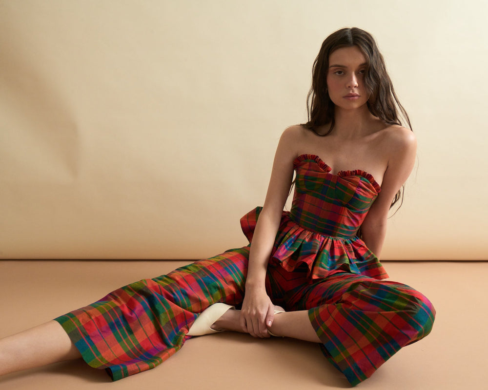 Seated front view of Libby Pant in Island Holiday showing tartan dupioni wide cropped leg on model against beige backdrop