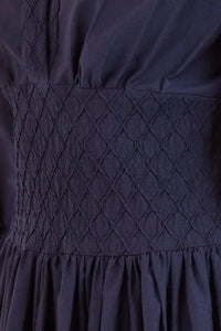 Navy diamond-smocked novelty shirting fabric with a soft V effect and blouson sleeves.