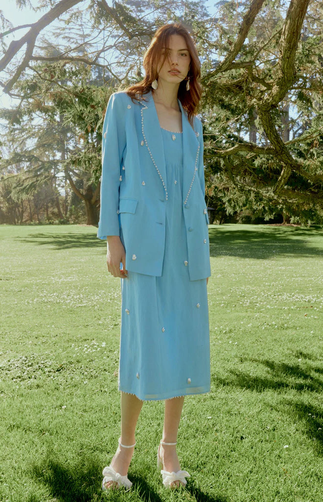 Front view of the light blue Sloan Blazer showcasing pearl trim and hyper-relaxed fit on a model outdoors