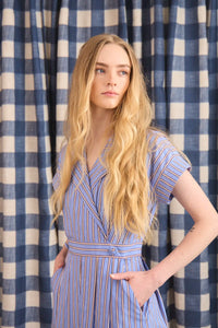 The Sloane Dress has a V-neckline, short banded sleeves, a fitted waist, and full midi-length skirt.