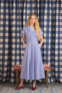 The Sloane Dress has a V-neckline, short banded sleeves, a fitted waist, and full midi-length skirt.