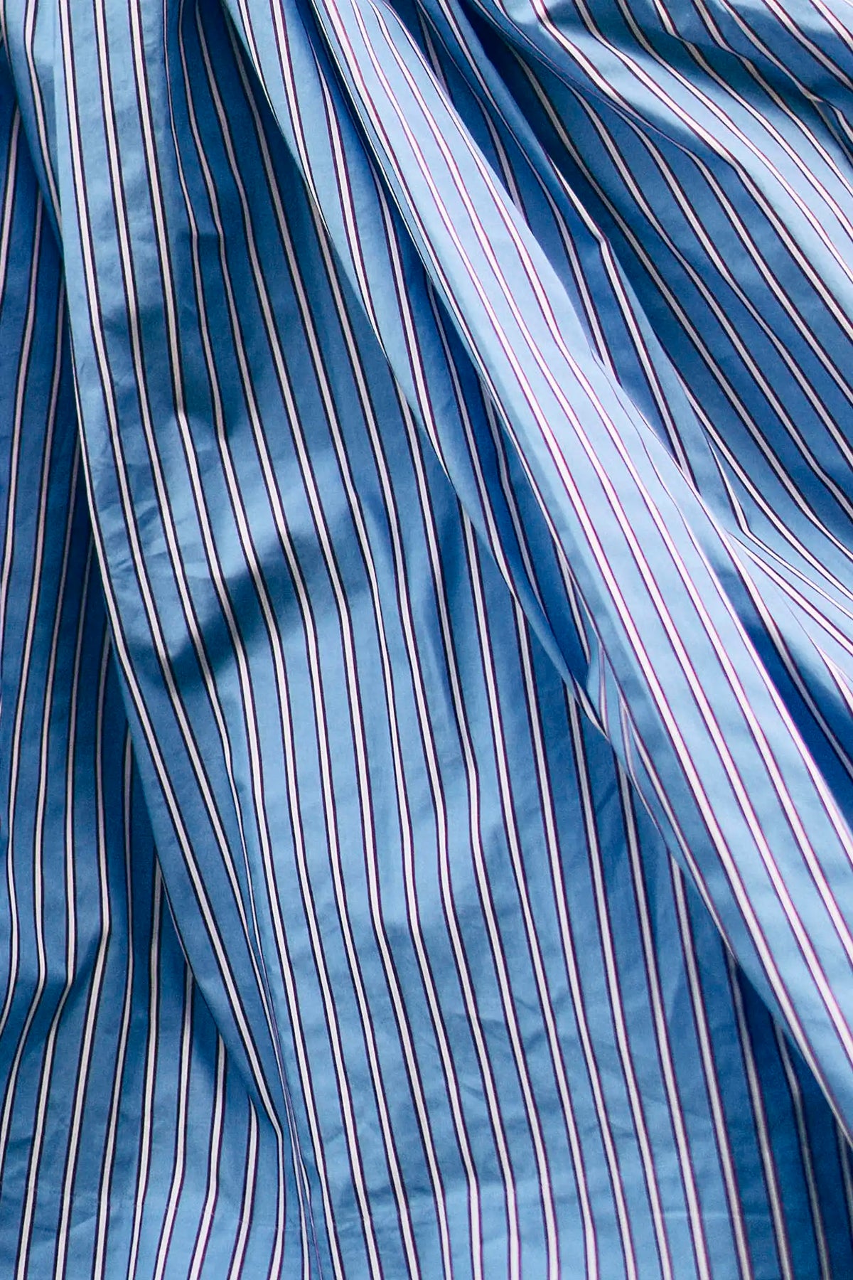 The Sloane Dress has a V-neckline, short banded sleeves, a fitted waist, and full midi-length skirt.