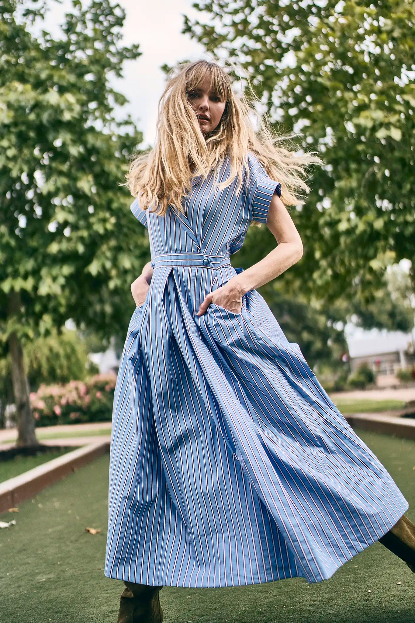 The Sloane Dress has a V-neckline, short banded sleeves, a fitted waist, and full midi-length skirt.
