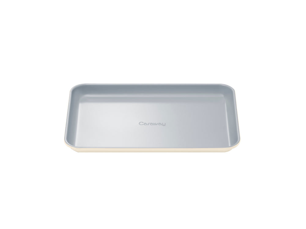 Top view of Small Baking Sheet showing ceramic coated gray interior, cream exterior and embossed Caraway name on white