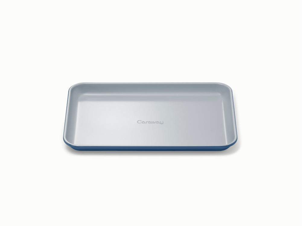 Top down view of Small Baking Sheet in navy showing shallow sides and smooth ceramic coated nonstick surface on white background