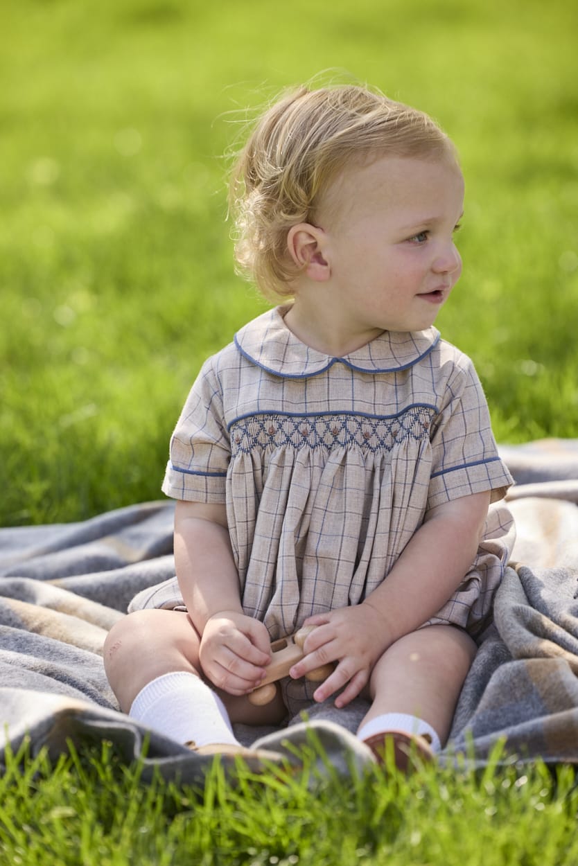 Little English classic children's clothing.  Smocked peter pan bubble in tan and blue Durham windowpane with blue piping for baby boys