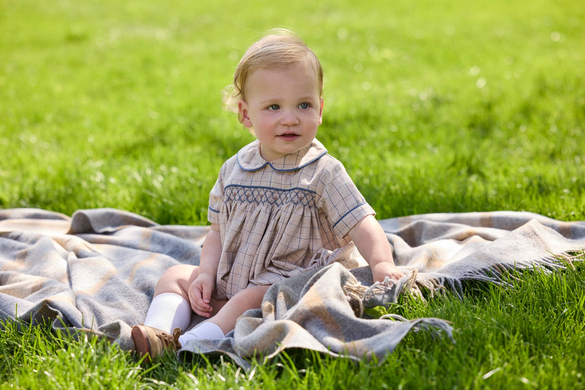 Little English classic children's clothing.  Smocked peter pan bubble in tan and blue Durham windowpane with blue piping for baby boys
