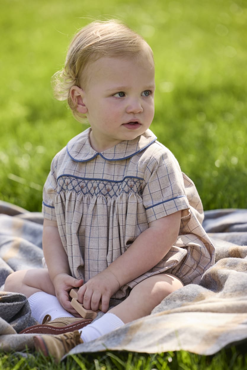 Little English classic children's clothing.  Smocked peter pan bubble in tan and blue Durham windowpane with blue piping for baby boys