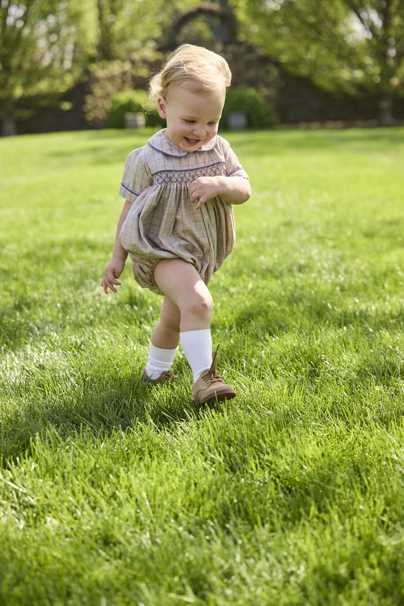 Little English classic children's clothing.  Smocked peter pan bubble in tan and blue Durham windowpane with blue piping for baby boys