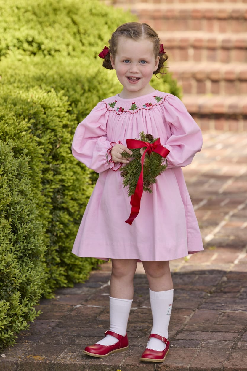 Little English traditional children's clothing.  Long sleeve pink corduroy dress with Christmas motif smocking around the neckline for little girls.
