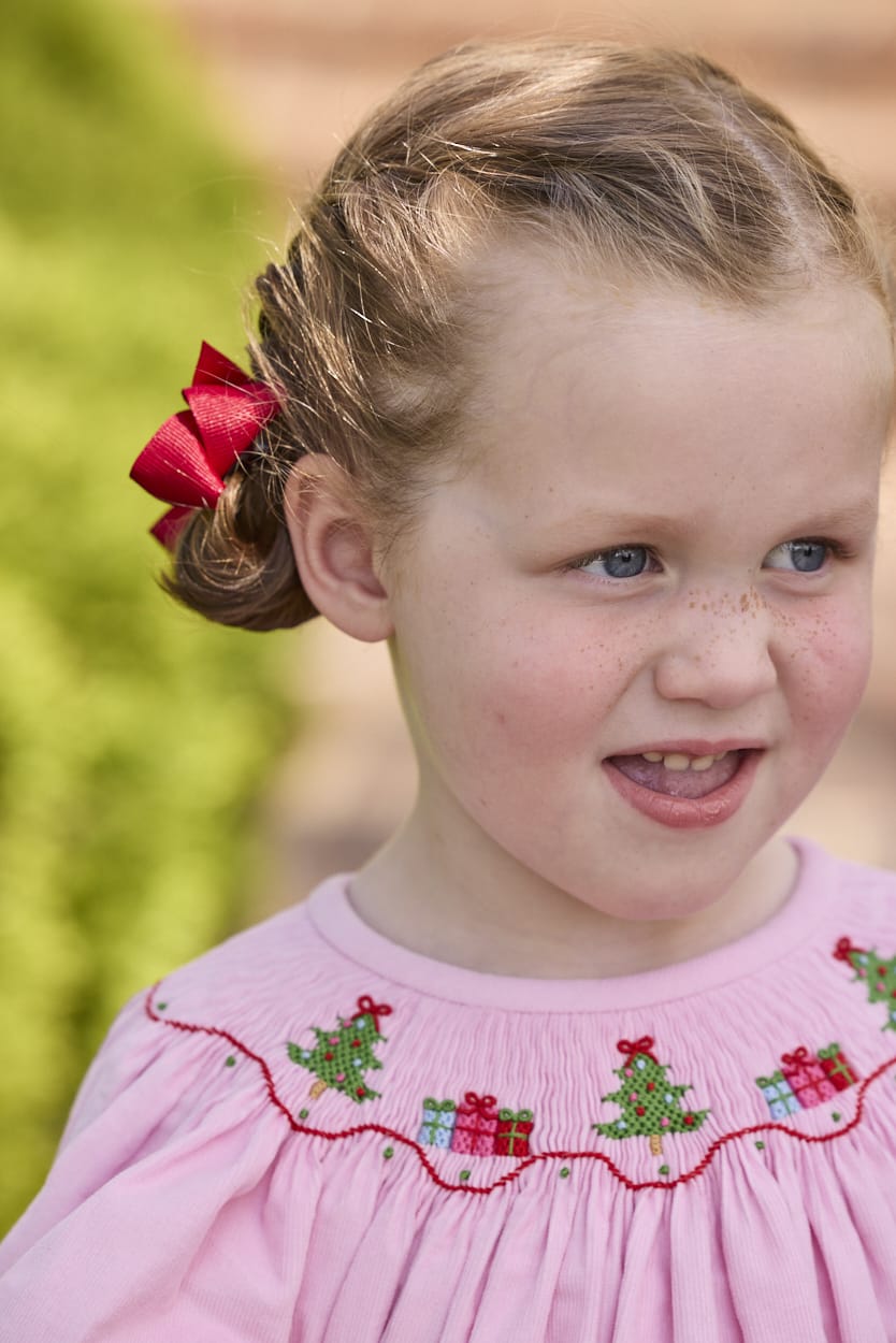 Little English traditional children's clothing.  Long sleeve pink corduroy dress with Christmas motif smocking around the neckline for little girls.