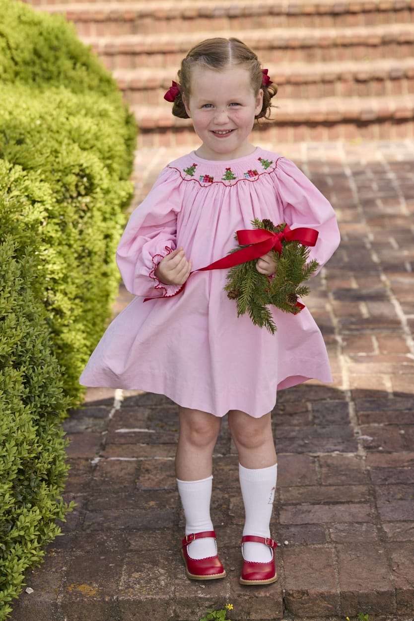 Little English traditional children's clothing.  Long sleeve pink corduroy dress with Christmas motif smocking around the neckline for little girls.