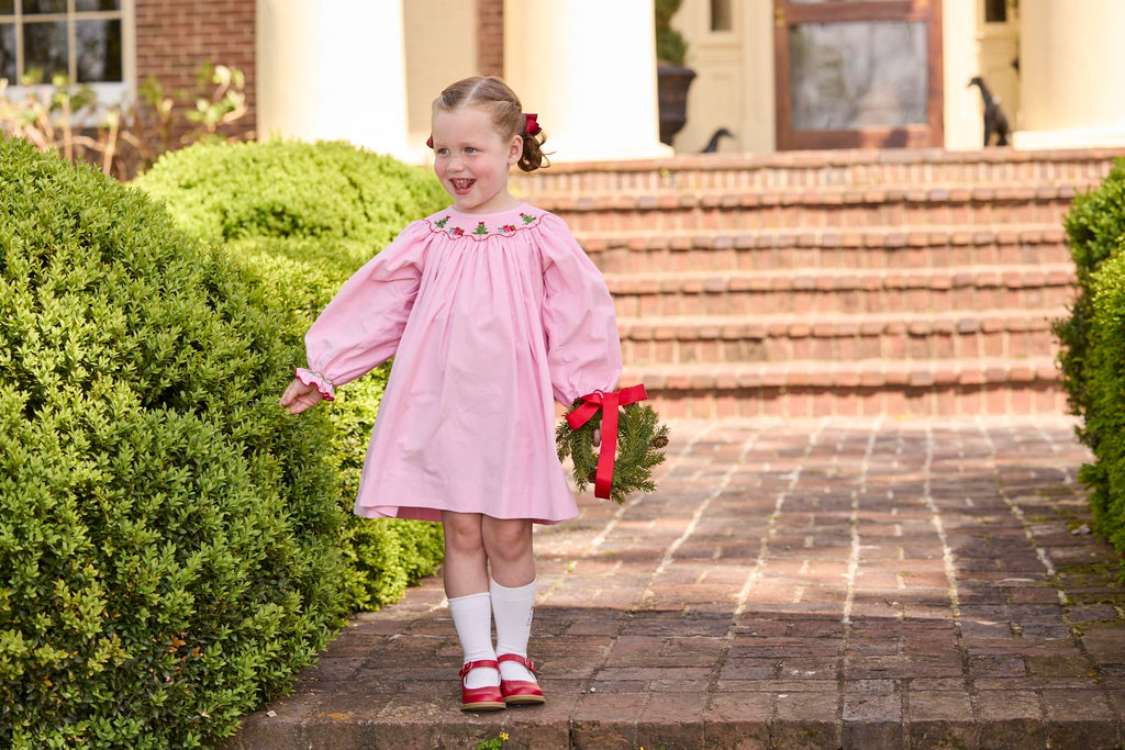 Little English traditional children's clothing.  Long sleeve pink corduroy dress with Christmas motif smocking around the neckline for little girls.