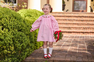 Little English traditional children's clothing.  Long sleeve pink corduroy dress with Christmas motif smocking around the neckline for little girls.