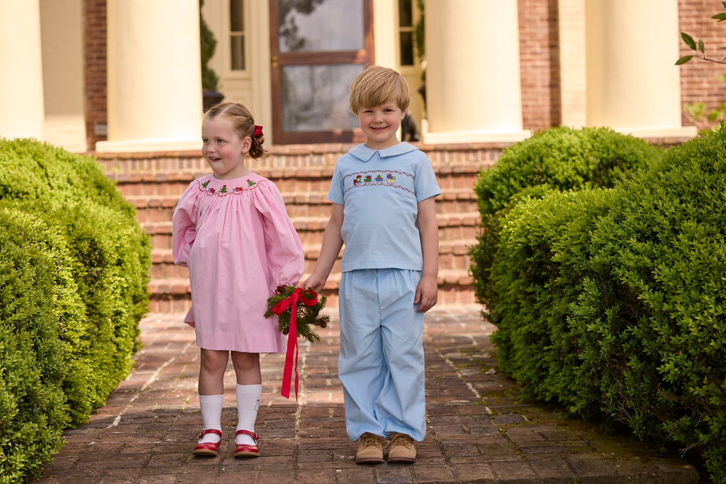 Little English traditional children's clothing.  Long sleeve pink corduroy dress with Christmas motif smocking around the neckline for little girls. Boys blue corduroy set - banded pants paired with Eaton collar short sleeve top with holiday train smocking across the chest.