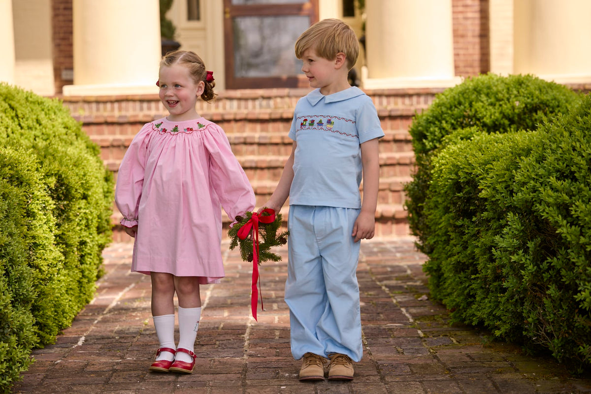 Little English traditional children's clothing.  Long sleeve pink corduroy dress with Christmas motif smocking around the neckline for little girls. Boys blue corduroy set - banded pants paired with Eaton collar short sleeve top with holiday train smocking across the chest.