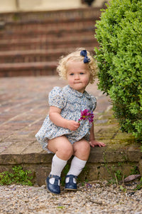 Little English classic children's clothing.  Dressy peter pan bubble for baby girls in blue Wisteria Floral with puff sleeves, ruffle details, and smocking at chest.